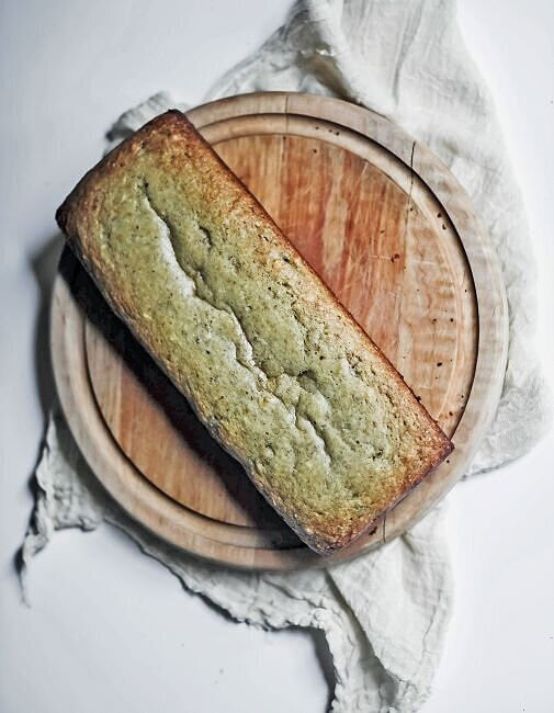 Loaf of homemade gluten free bread on wood board.