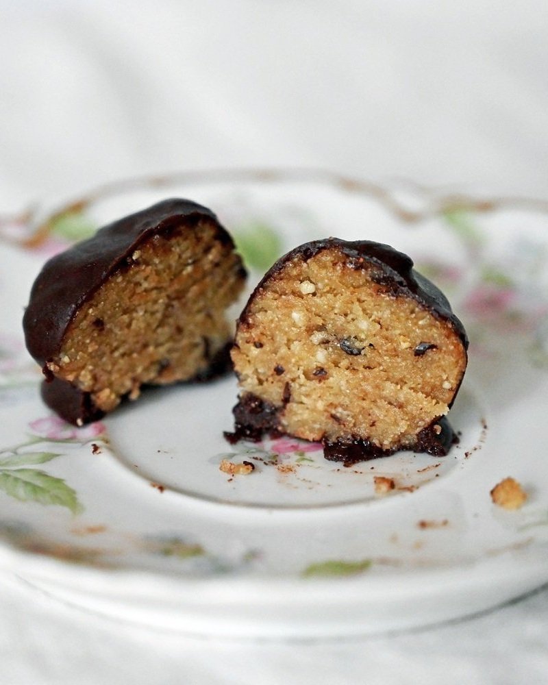Chocolate covered gluten free and vegan no bake cookie dough bite with two halves.