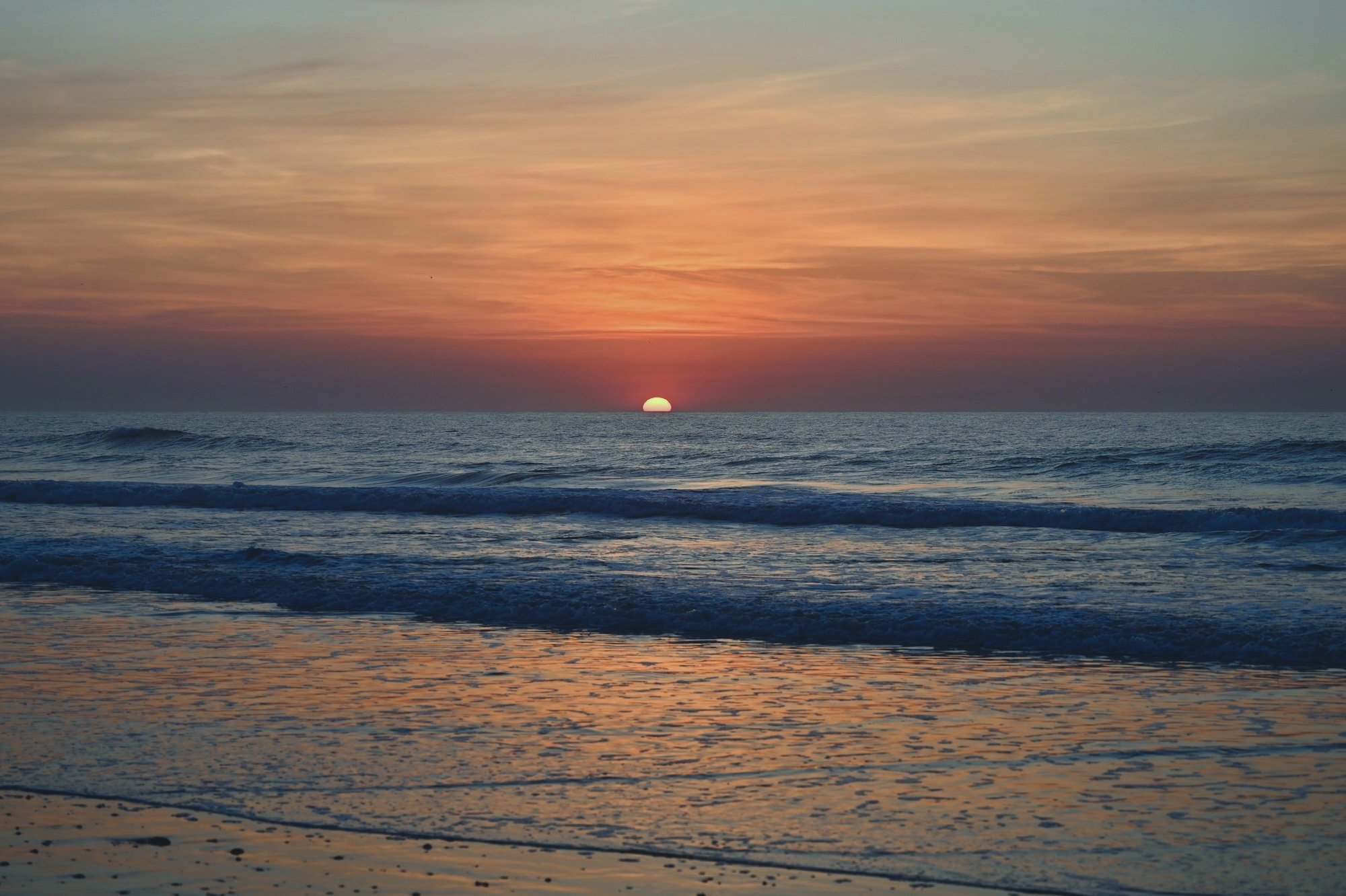 Sunrise over ocean waves.